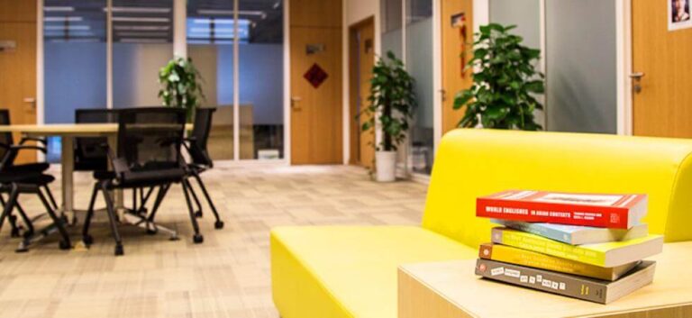 Study space with yellow couch, table and chairs, and several books