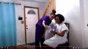 Frame from a patient-teaching video: A patient receiving instruction on the use of a medical device